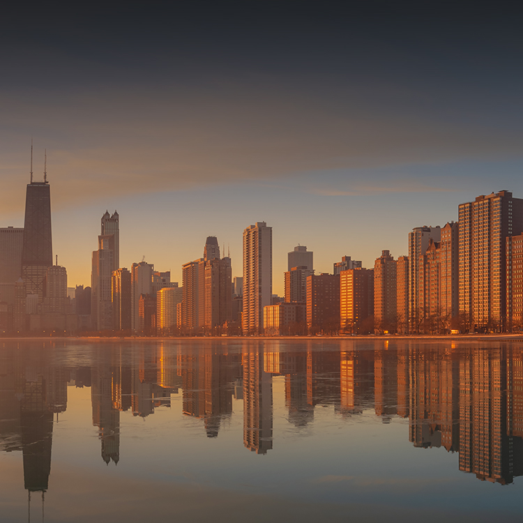 A stunning view of the Chicago skyline at sunset, with colorful clouds in the sky and buildings illuminated by the fading light.