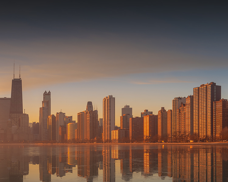 A stunning view of the Chicago skyline at sunset, with colorful clouds in the sky and buildings illuminated by the fading light.